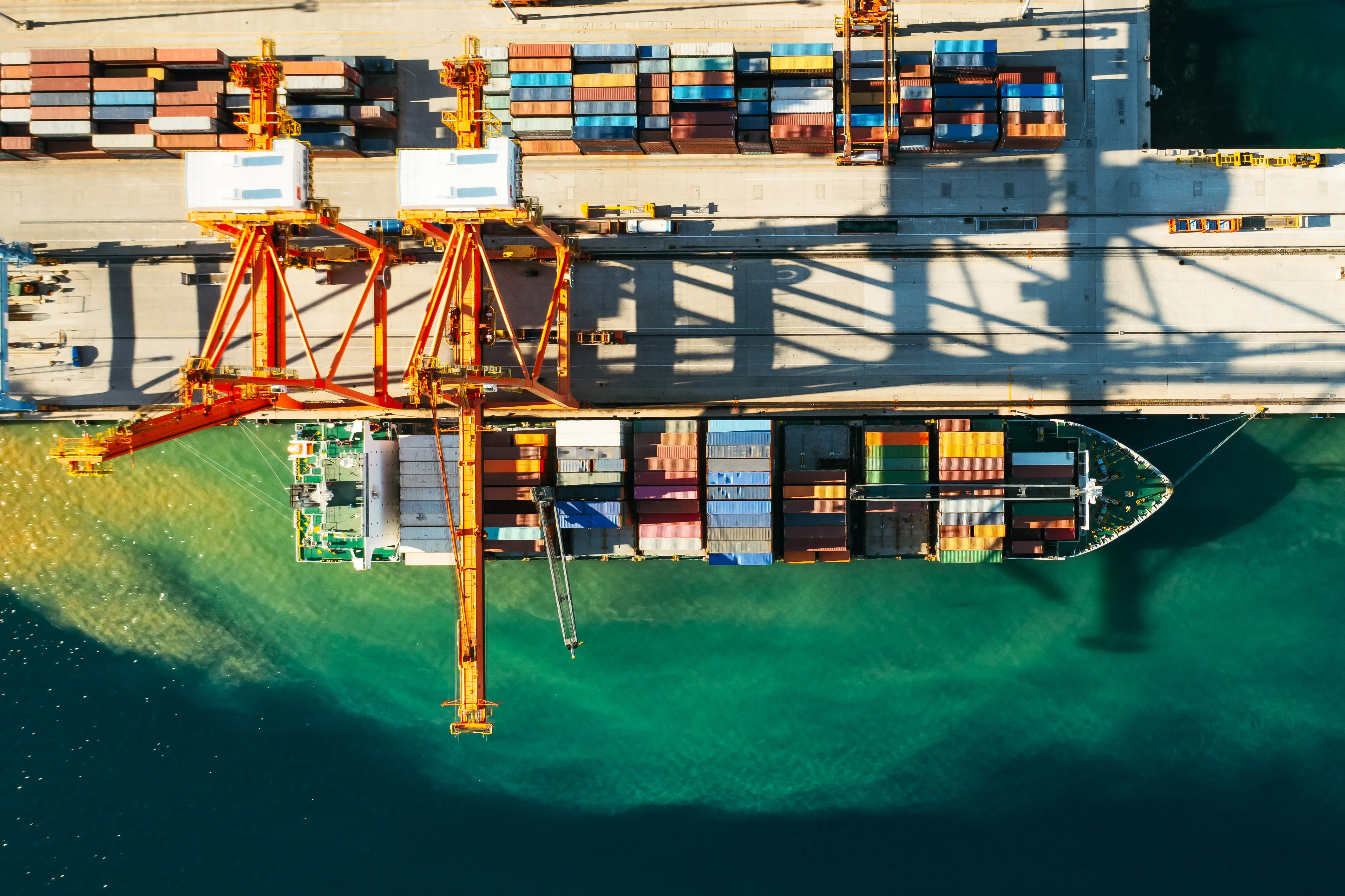 Aerial view of containers being loaded and unloaded at a freight terminal.